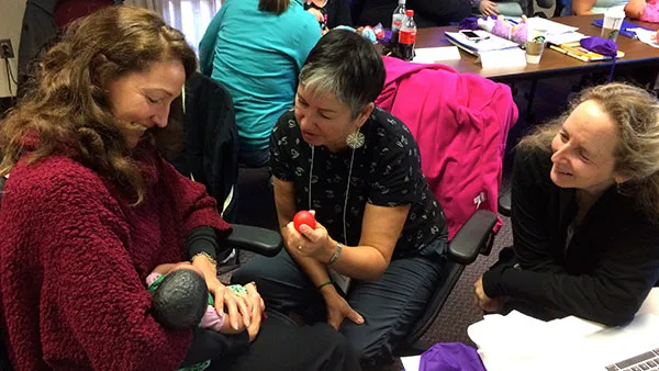 3 ladies looking at a baby mannequin 