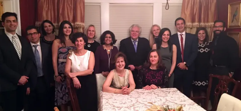 Kourembanas lab members stand behind Stella Kourembanas at a formal dinner.