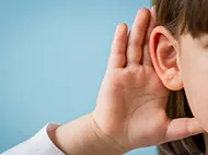 child holding hand up to ear